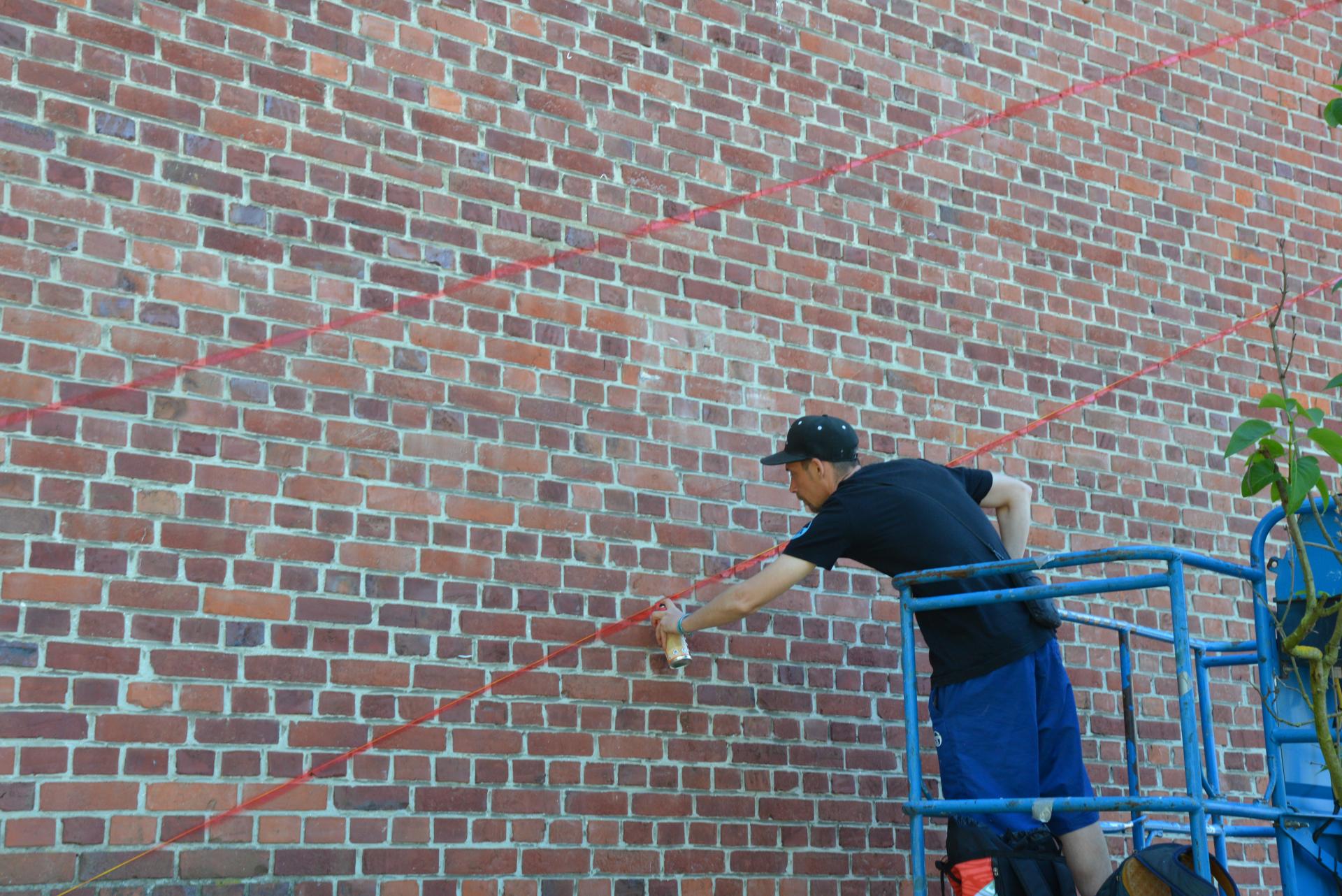 L'artiste ASTRO commence la réalisation de sa fresque.